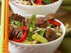 Im Wok karamelisiertes Schweinefleisch mit Peperoni, Honig und Koriander